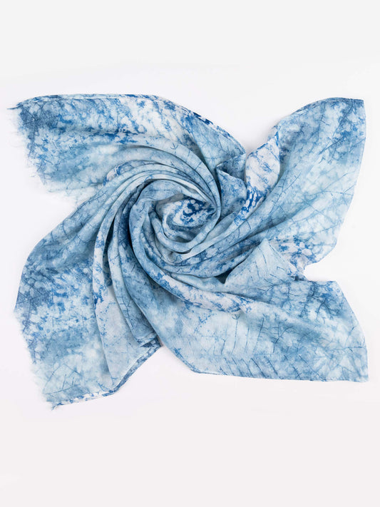 A lightweight square scarf with a blue and white tie-dye shibori pattern, styled in a central swirl on a plain white background.