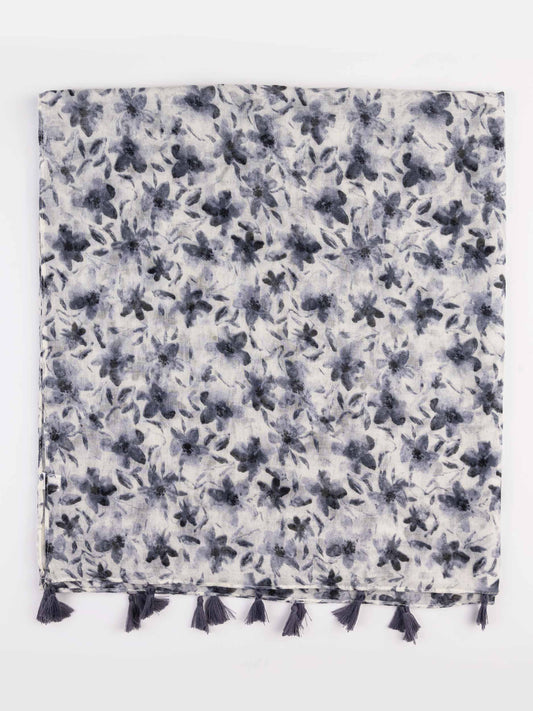 A square scarf with a dense floral and leaf pattern in dark navy blue and gray on a white background, finished with a row of dark tassels along one edge.