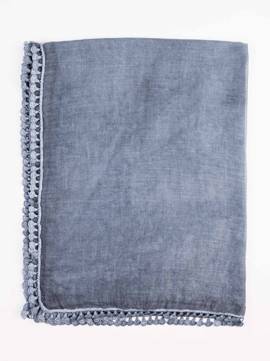 Blue denim towel with tassel trim on a white background